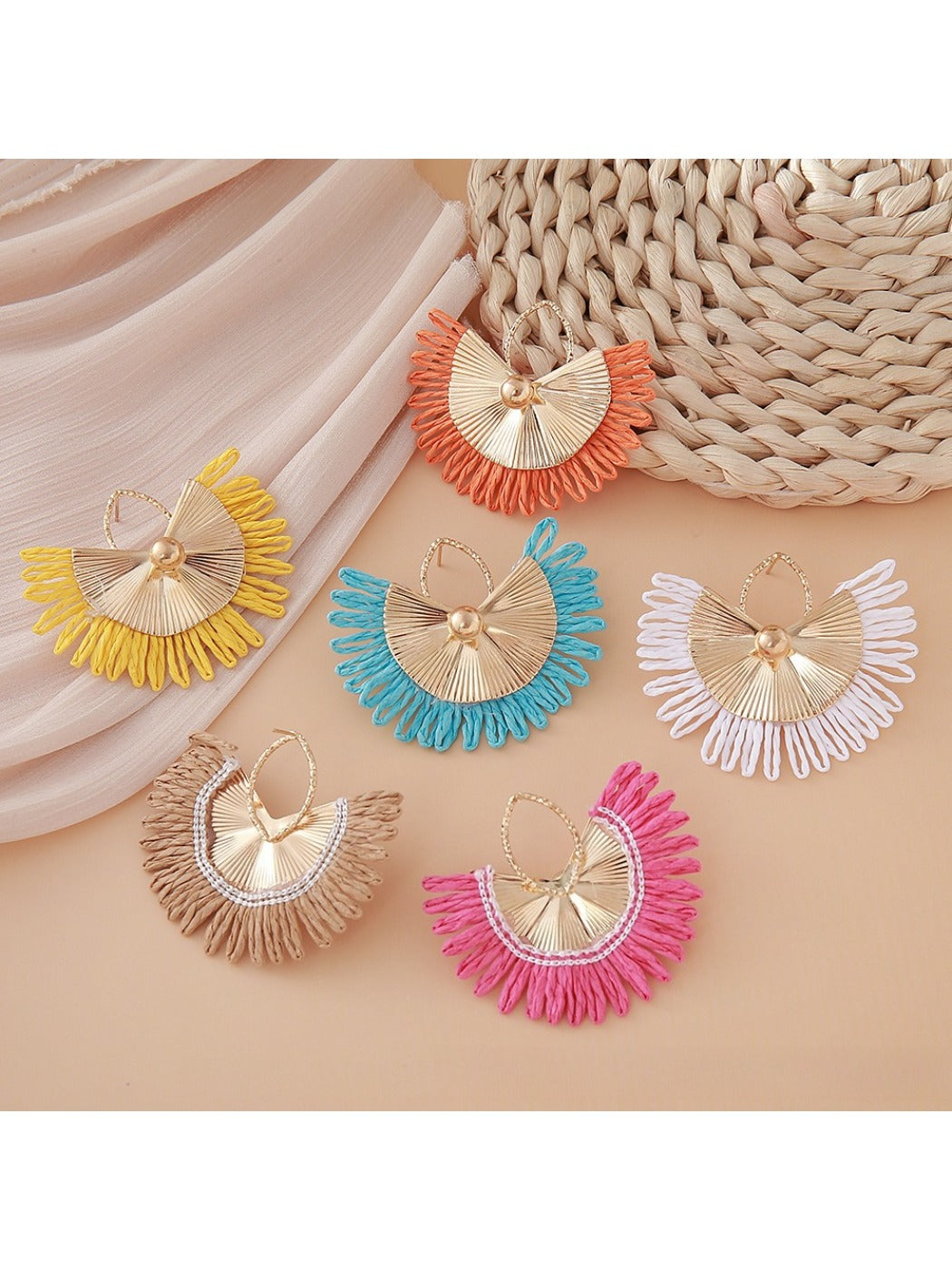 Earedge raffia woven fan shape earrings displayed hanging on a stand