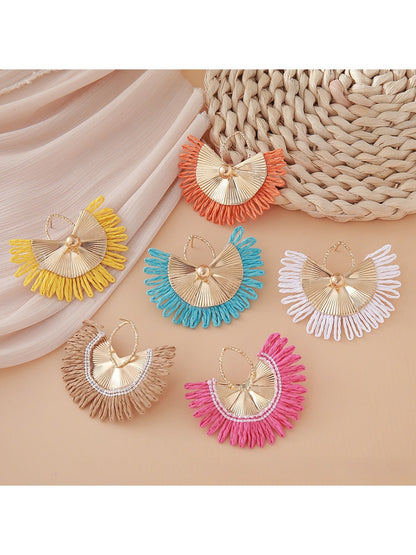 Earedge raffia woven fan shape earrings displayed hanging on a stand