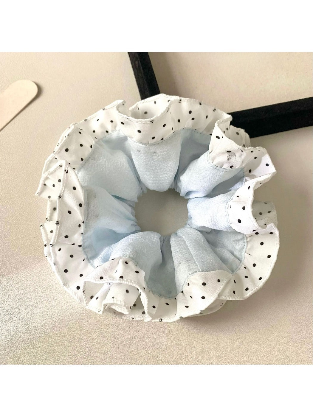 Gifty scrunchie worn on wrist as a fashion accessory with polka dot and color block design