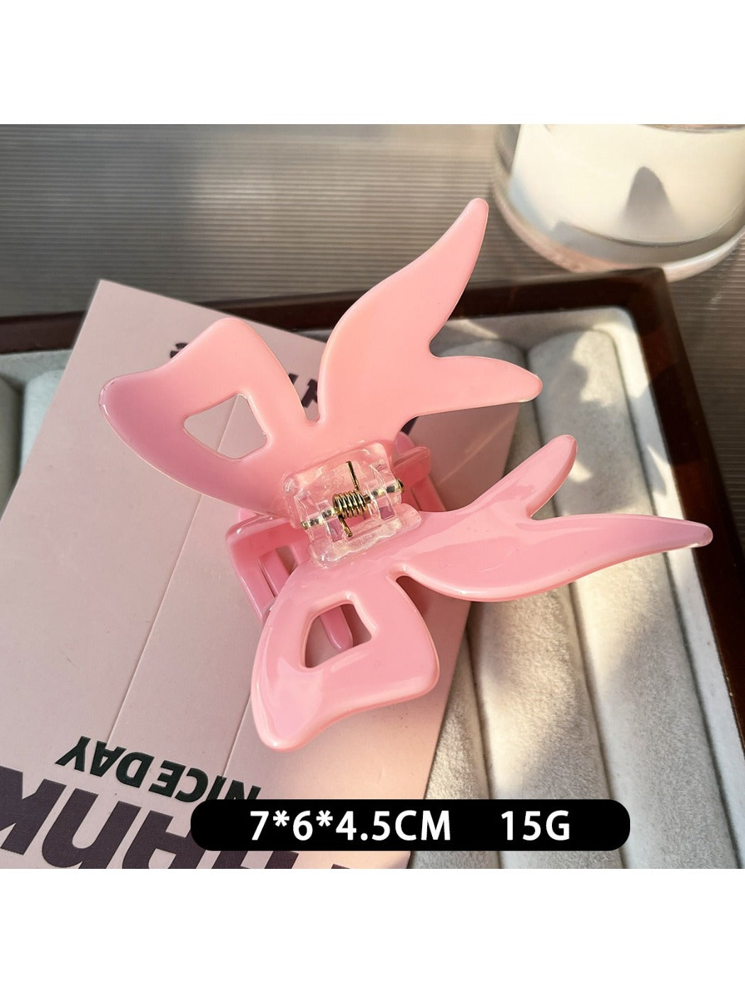 Beau bow claw clip placed on wooden surface with natural lighting