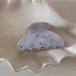 Beau acetate updo claw clip placed on wooden surface with natural light