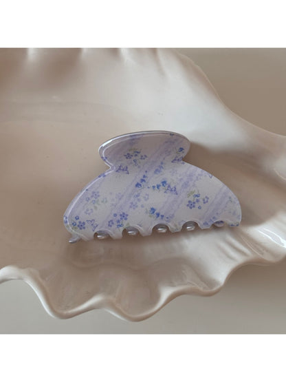 Beau acetate updo claw clip placed on wooden surface with natural light