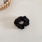 Satin bow scrunchie styled with a casual outfit and minimal makeup on a model
