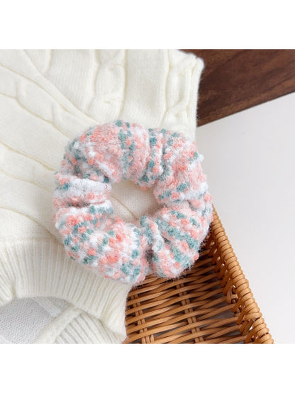 Flat lay of assorted colorful scrunchies and headbands on a neutral background