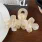 Beau hair claw clip positioned on a fabric background emphasizing texture and design