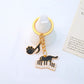Cartoon cat piano keychain displayed on a wooden surface