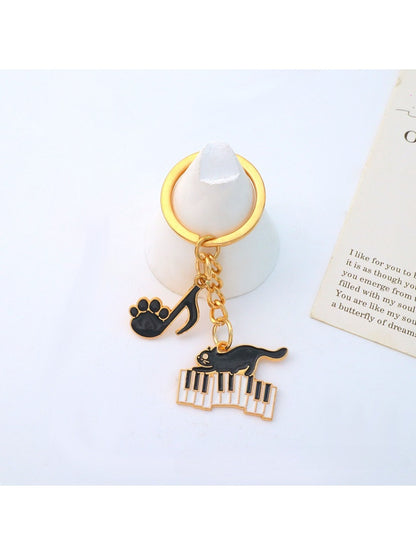Cartoon cat piano keychain displayed on a wooden surface