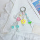 Close-up of Keypus star charm with smiling face and flower charm on keychain