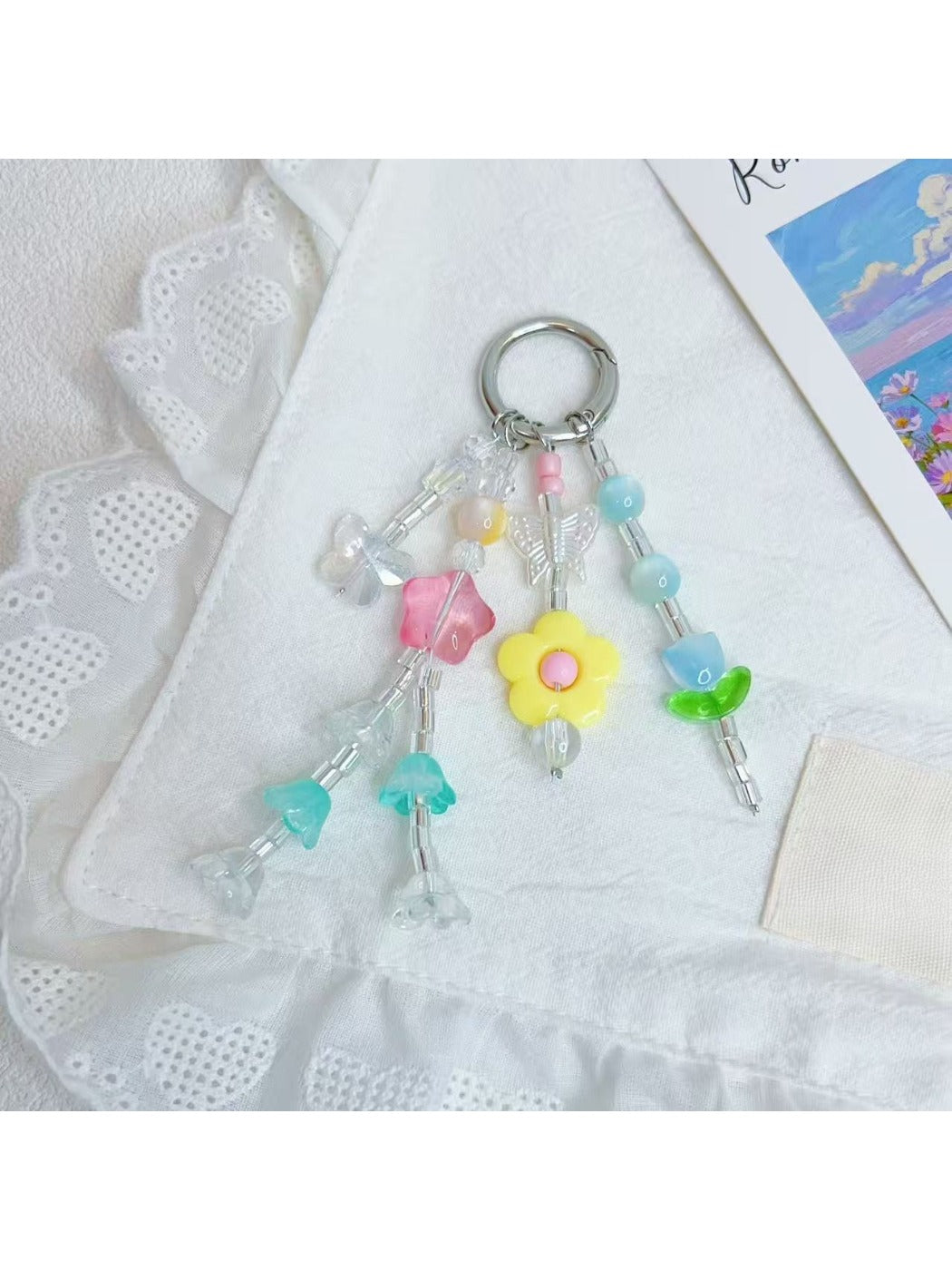 Close-up of Keypus star charm with smiling face and flower charm on keychain
