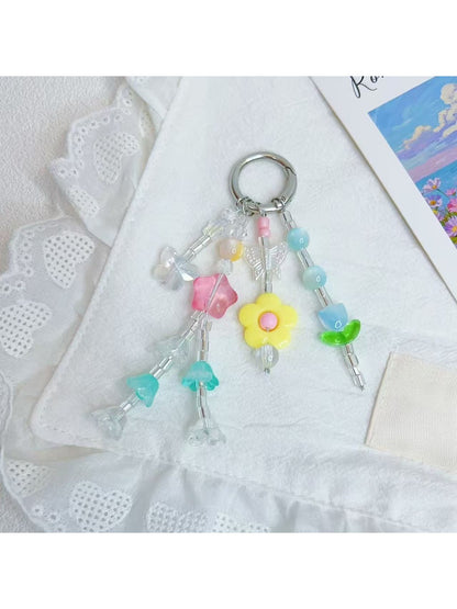 Close-up of Keypus star charm with smiling face and flower charm on keychain