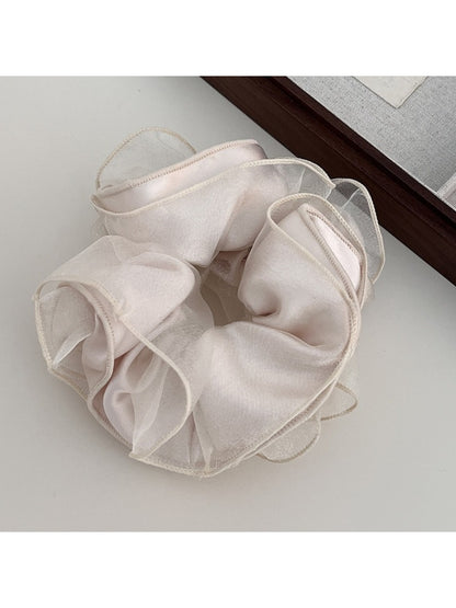 Gifty scrunchie worn on wrist highlighting satin fabric and ruching