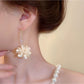 Pair of Hydrangea shaped drop earrings displayed on a white background