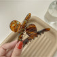 Beau brown acetate claw clip holding hair in a half-up hairstyle