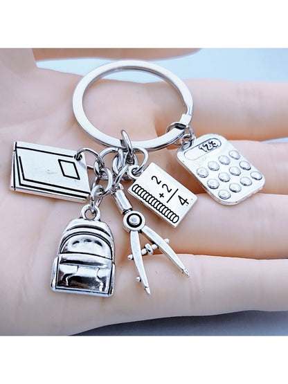 Alloy backpack-shaped keychain with book design on a white background