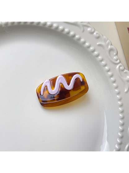 Beau hair clip displayed with matching accessories on table