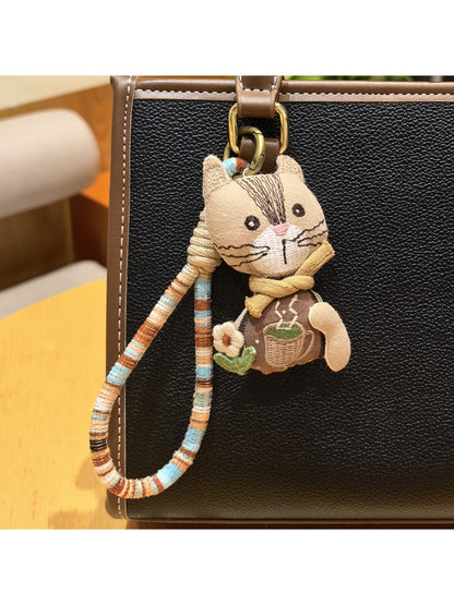 Hand holding vintage cat charm keychain showing size and detail