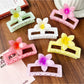 Close-up of Beau square ombre flower shaped claw clip showing petal details and clasp mechanism