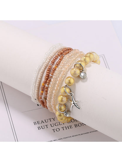 Lovra star pendant bracelet styled with casual outfit on model's wrist