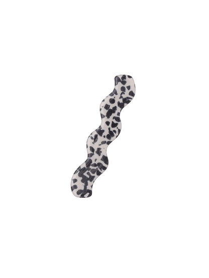 Beau hair clip positioned on wooden surface showing shape and size