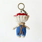 Keypus fabric doll keychain displayed on a wooden surface with soft lighting