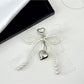 Lace bow keychain attached to a set of keys on a wooden surface