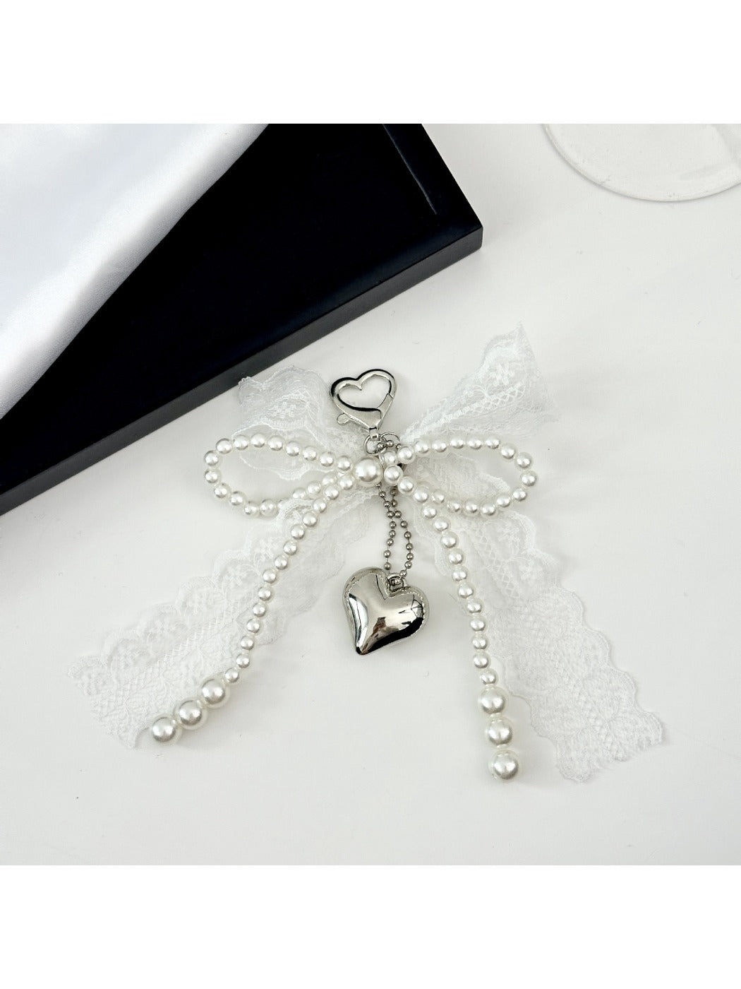 Lace bow keychain attached to a set of keys on a wooden surface
