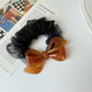 Gifty scrunchie styled in a ponytail with mesh bow accent