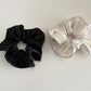 Gifty satin finish scrunchie wrapped around a ponytail on a model