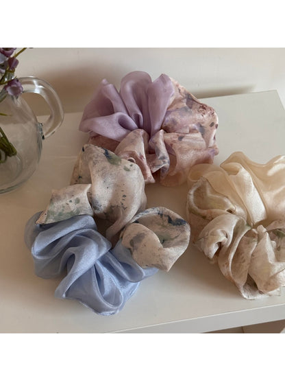 Gifty scrunchie styled on a wrist with soft gradient colors