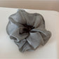 Scrunchie styled in a bun with soft romantic look and floral details