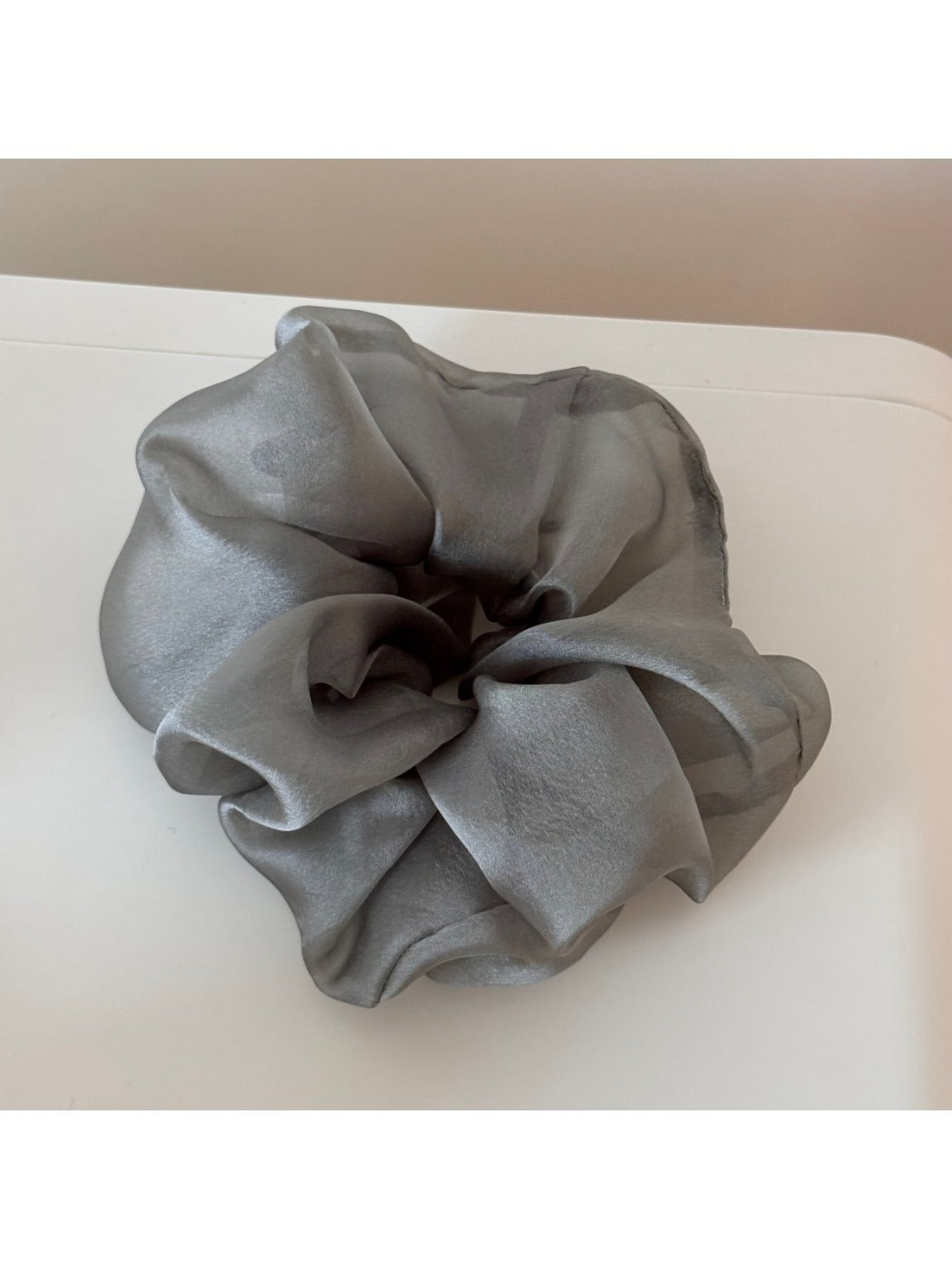 Scrunchie styled in a bun with soft romantic look and floral details