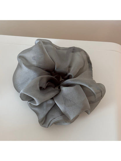 Scrunchie styled in a bun with soft romantic look and floral details