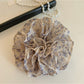 Gifty scrunchie styled on a wrist highlighting vintage floral print and gathered fabric