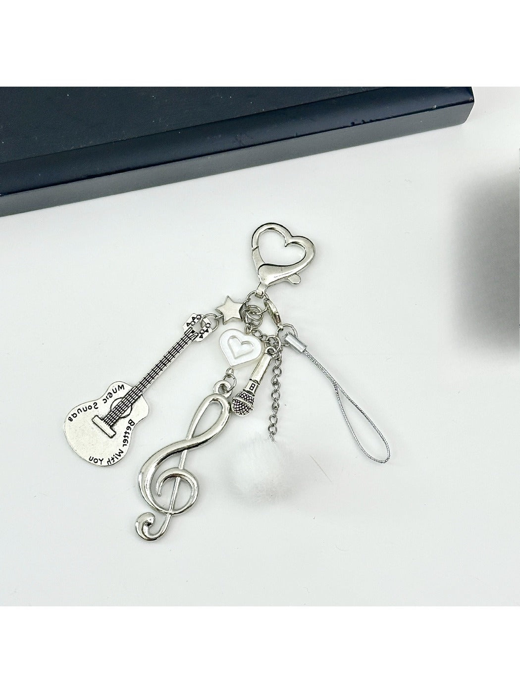 Keypus music style note keychain displayed hanging from a set of keys on a wooden surface