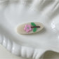 Beau oval hair clip placed next to matching accessories on a wooden surface