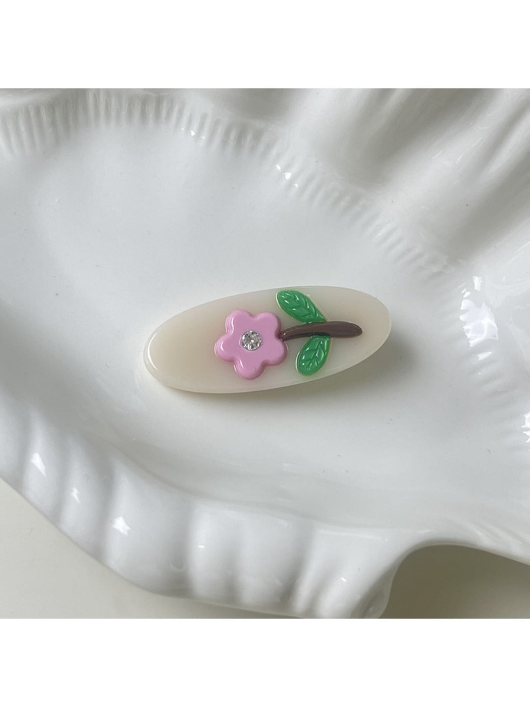 Beau oval hair clip placed next to matching accessories on a wooden surface