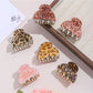 Close-up of Beau leopard print hair clip with gold-tone clasp on white background