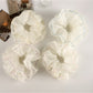 Close-up of Gifty double layer scrunchie in soft pastel pink fabric
