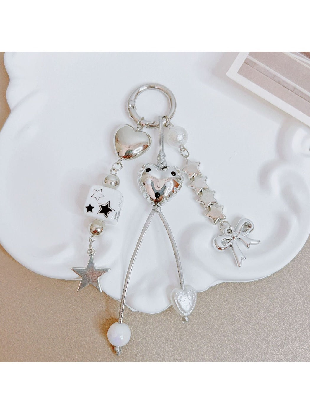 Keypus keychain showing star and bow charms hanging from gold ring