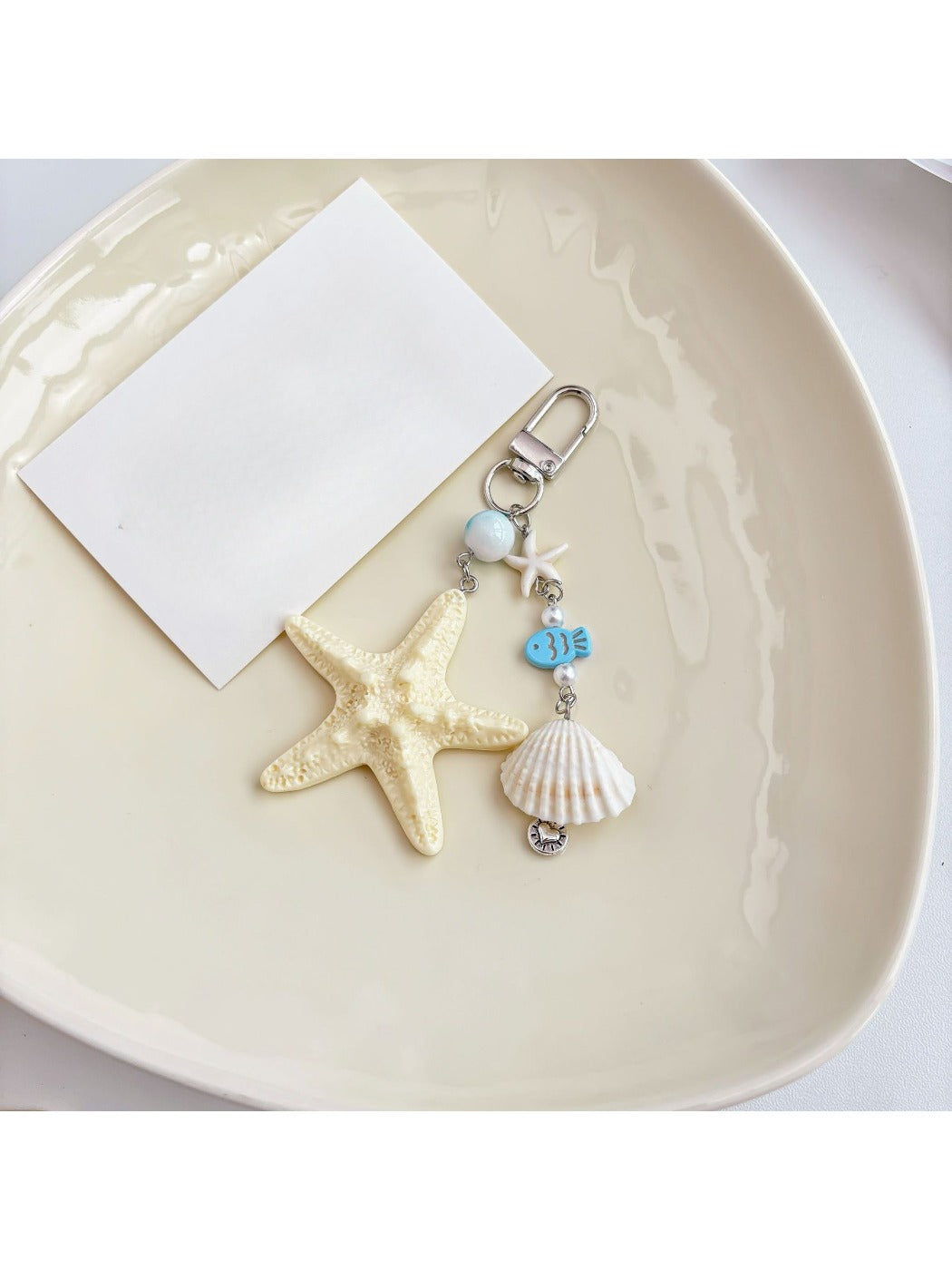 Detailed view of the small fish charm on the ocean-themed keychain