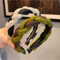 Close-up of vintage knitted twist headband in beige on white background