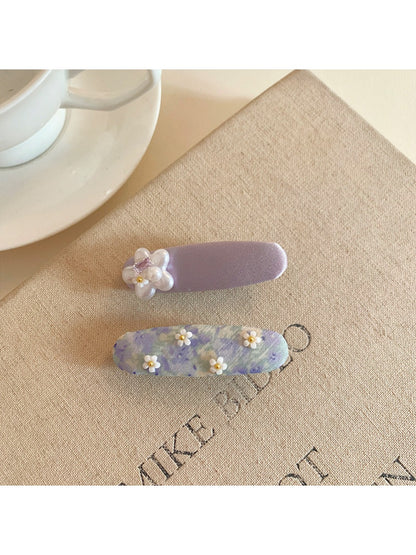Model wearing Beau purple tiny flower hair clip in styled hair