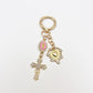 Vintage cross pendant keychain next to a leather wallet and keys