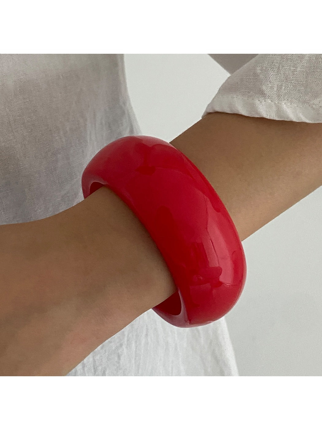 Lovra wide round bangle bracelet displayed with focus on smooth, seamless metal finish