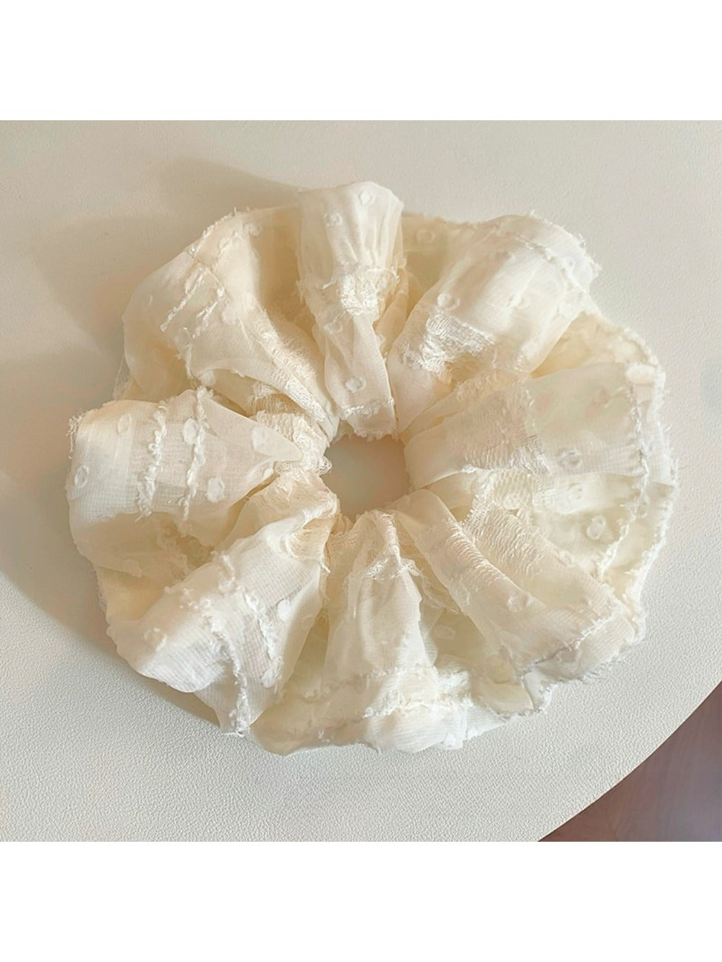Close-up of a chic solid color ruffled scrunchie on a white background