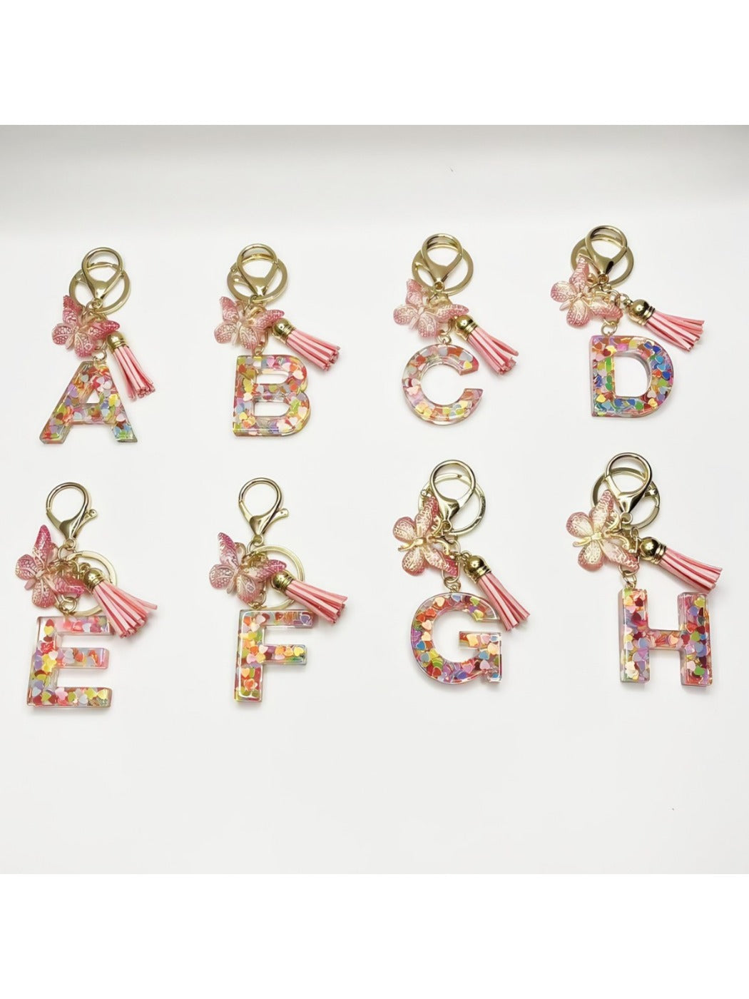 Silver keychain featuring a butterfly and letter pendant on a white background