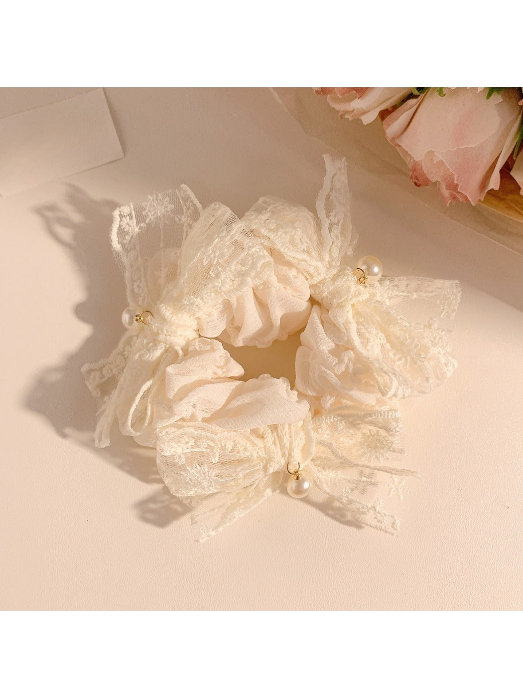 White lace bow scrunchie displayed with matching accessories