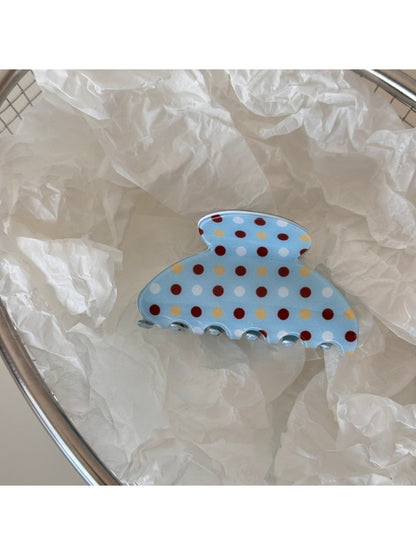 Blue hair clip with white dots shown from top angle