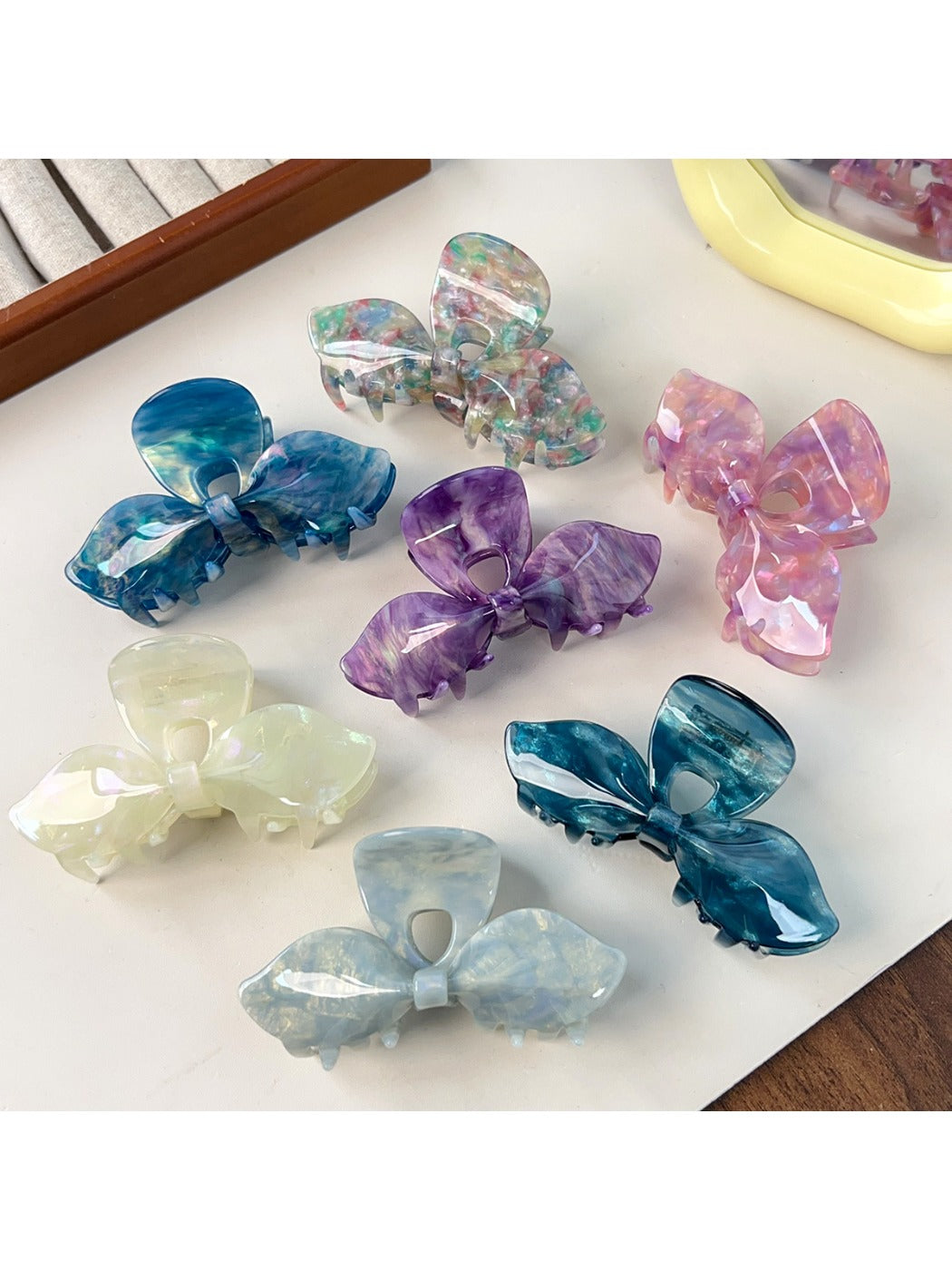 Close-up of iridescent bow hair claw clip showing glossy finish