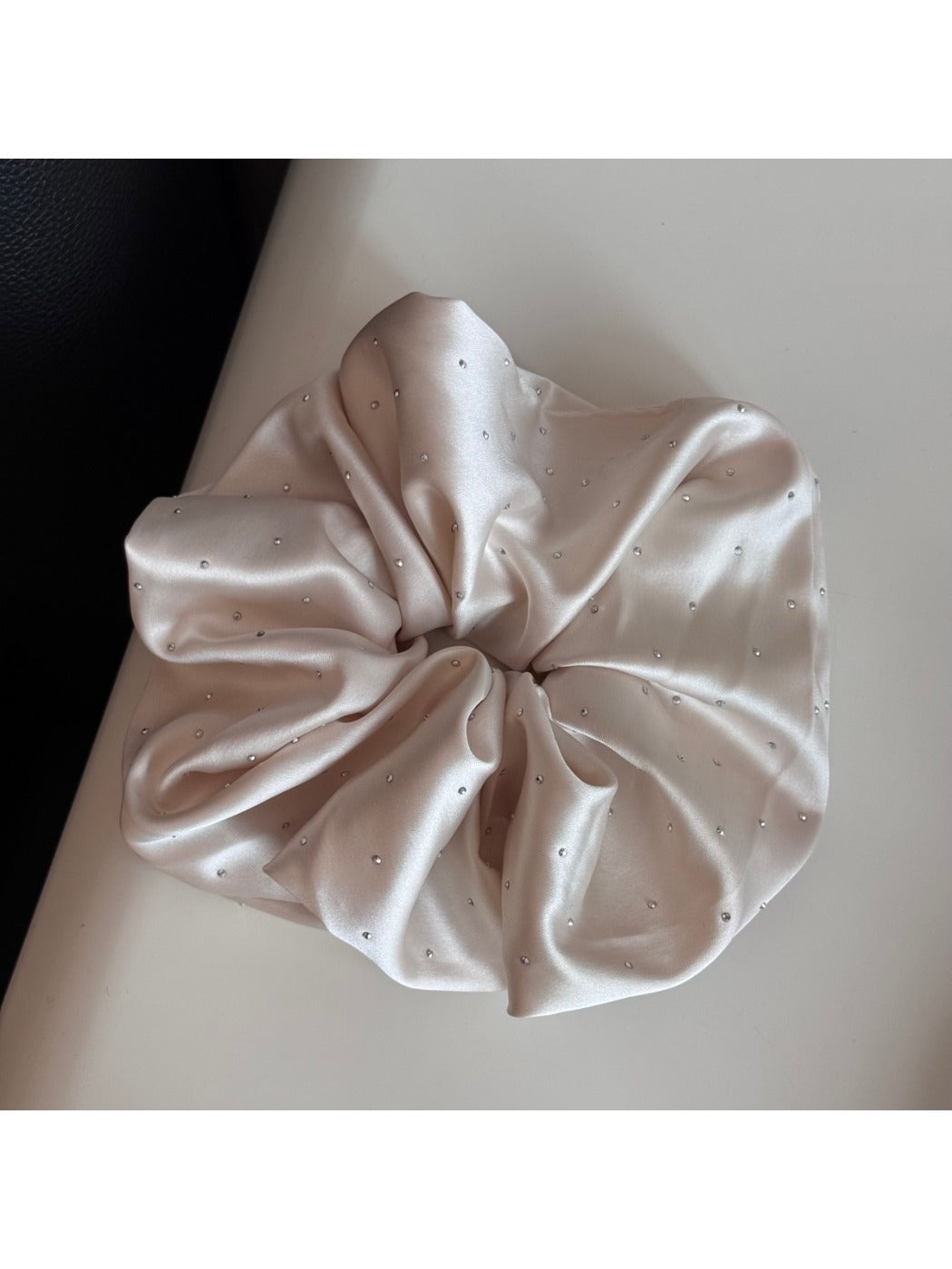 Gifty rhinestone satin scrunchie styled on a model's wrist